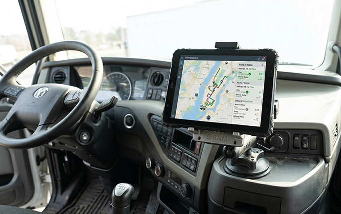 Long-haul truck dashboard with rugged tablet mounted on RAM arm for fleet telematics and ELD compliance during highway operation